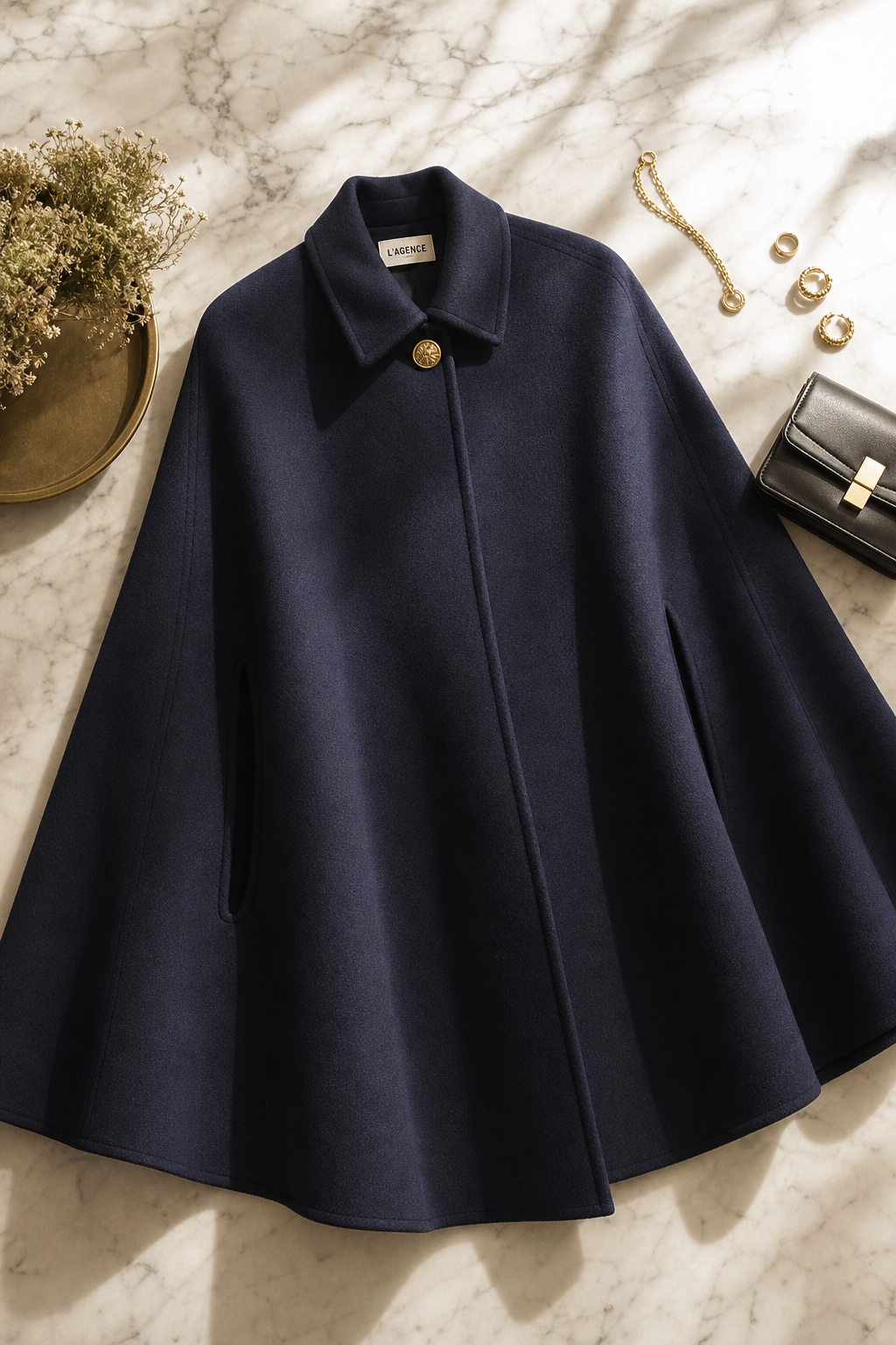 a beautiful editorial flat-lay of an elegant dark navy wool cape coat draped