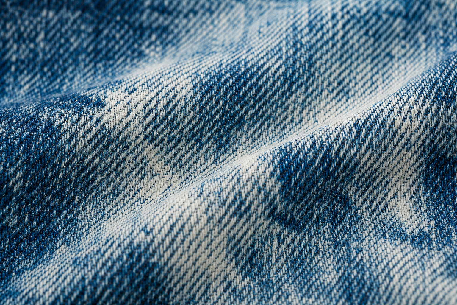 a close-up detail shot of ice-washed denim fabric texture showing the