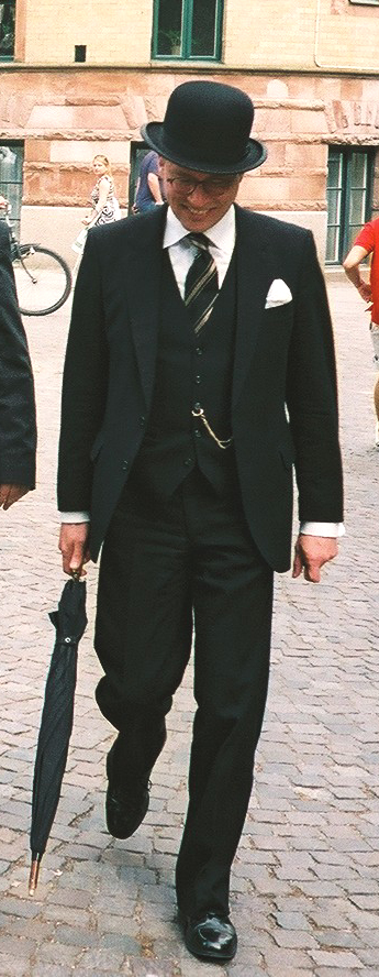 مردی با کت‌وشلوار سه‌تکه و کلاه کاسه‌ای (bowler hat)